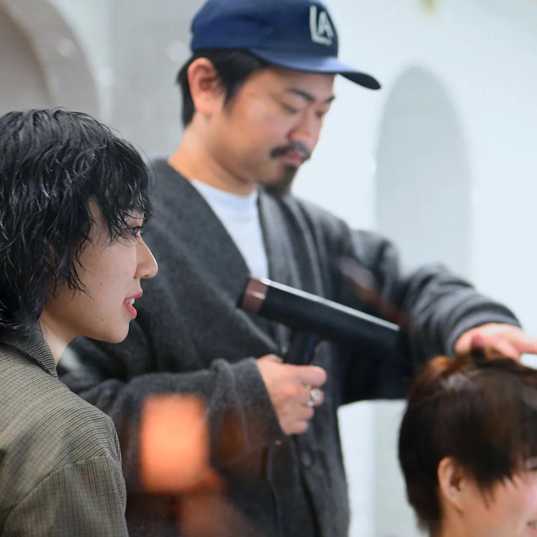 先輩スタッフがカットを教えている様子